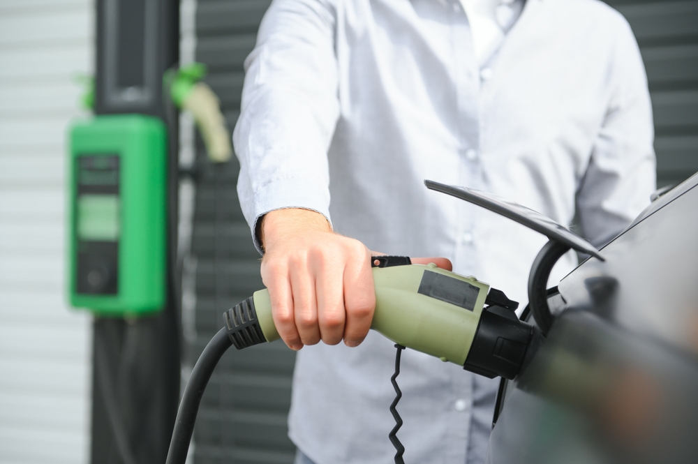 hombre adulto cargando coche electrico